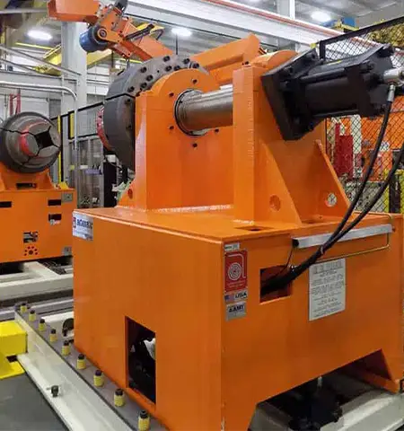 Industrial metal coil uncoiler machine with mounted steel coil in manufacturing facility